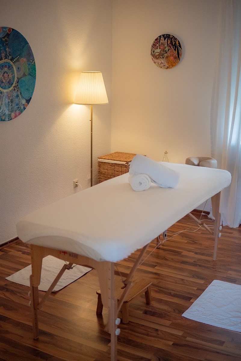 Massageliege mit frischen, gerollten Handtüchern