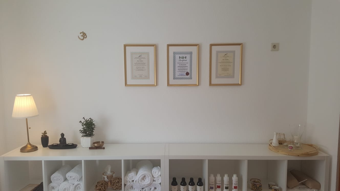 Regal mit gerahmten Zertifikaten, Handtüchern und Massageölen